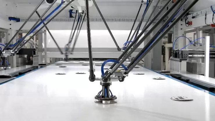 Robotic arm picking abrasive disks on conveyor